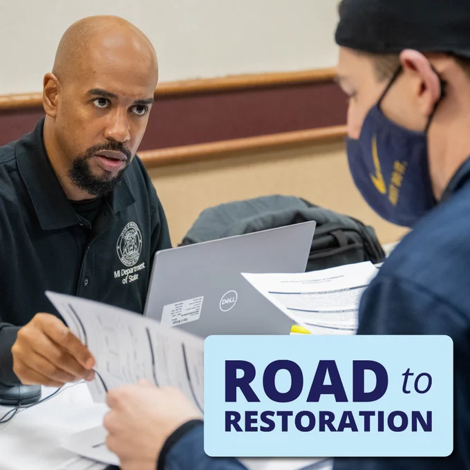 A Department of State staff member assists a Road to Restoration clinic attendee