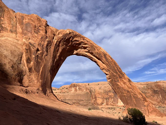 Natural sandstone arch with surrounding red rock formation outside Moab, Utah, named Corona Arch located on Bureau of Land Management land.
