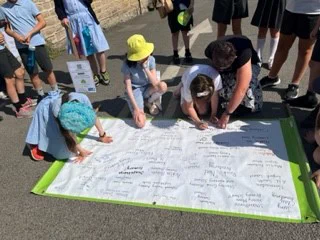 Children taking part in Wakefield Schools Climate Relay signing a banner