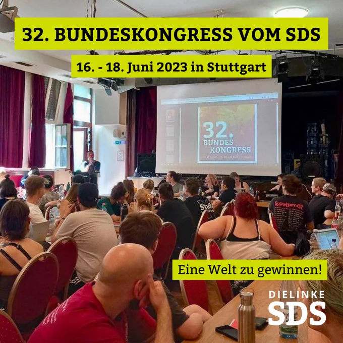 Bild vom 32. Bundeskongress vom SDS. Zu sehen sind ca. 20 Menschen, die einem Wortbeitrag zuhören. 