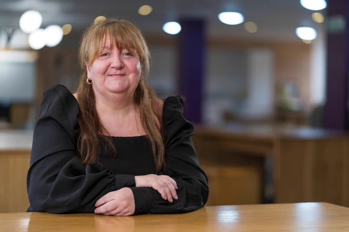 An image of Mary Edmiston sitting at a table