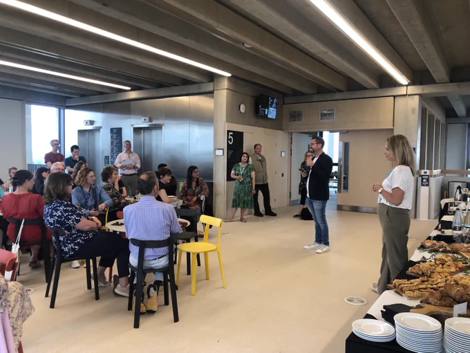 Man stood at the front of a room addressing them
