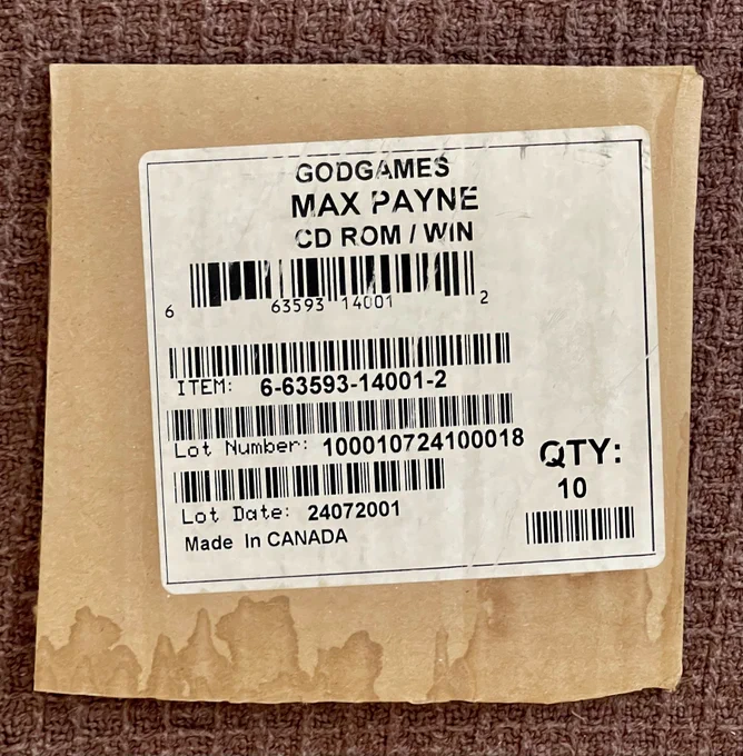Packaging from the original carton of MAX PAYNE, that would have been delivered to stores.

This sticker on a piece of cardboard shares:

"GODGAMES
MAX PAYNE
CD ROM ? WIN

QTY:
10

Made in CANADA"