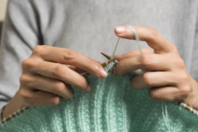 A close-up shot of a person knitting.