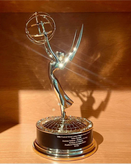 The golden emmy award. On the base reads: "54th Central Great Lakes Chapter Emmy Awards; Video Essayist; Journey Indiana - Memory Carvings; Saddam Al-Zubaidi; Producer/Videographer/Editor; WTIU"