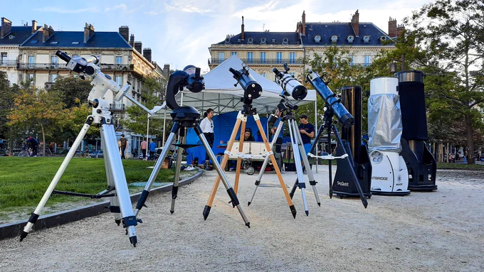 Photos de personnes observant le ciel à travers des télescopes, depuis la place Victor Hugo à Grenoble. L'un d'entre eux prend une photo avec son smartphone, d'autres posent des questions aux animateurs et animatrices présents sur place.