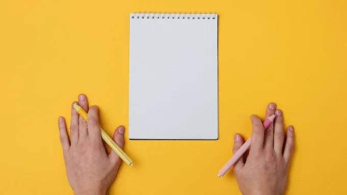 Image of a left hand and a right hand, both holding a pen