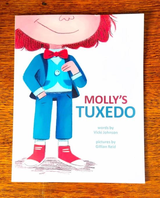Book cover, child standing in red tennis shoes, blue tux and vest and red bow tie, lower part of child's face is showing, smiling, with red hair and peach skin; the child has a hand in their pocket and is touching the vest with pride