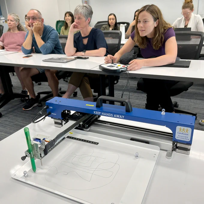 Members of SET-BC watch as one of the educators plays with the Accessible Art Interface.