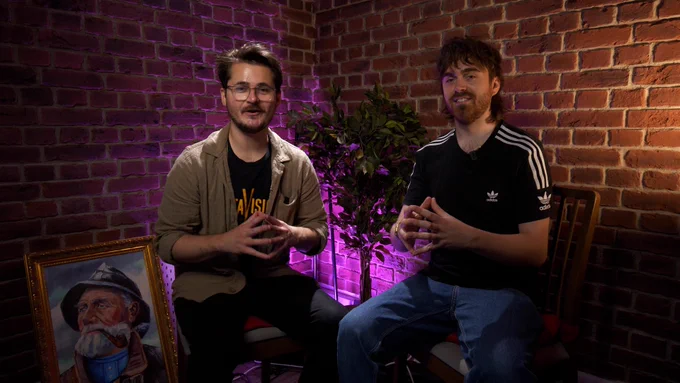 A picture of Tom B & Luke, both doing the same "touching fingertips" pose in the Games Night room set.