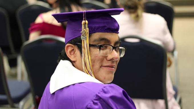Student in purple graduation hat and gown