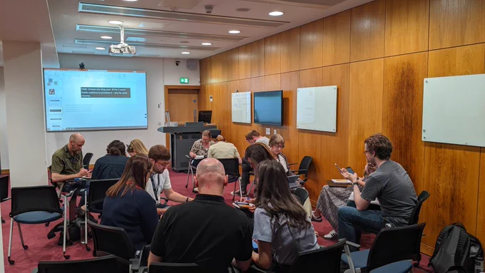 People seated down working in groups. 