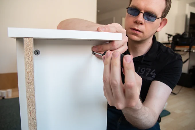 Das Foto zeigt unseren Kollegen Martin während er das Billy-Regal eigenhändig aufbaut.
The photo shows our colleague Martin assembling the Billy bookcase by himself.