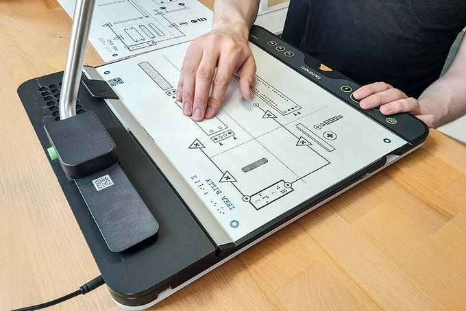 Das Foto präsentiert eine Nahaufnahme des Tactonom Readers, auf dem die detaillierte Grafik des IKEA Billy Regals zu sehen ist. The photo presents a close-up of the Tactonom Reader, featuring the detailed graphic of the IKEA Billy bookcase.