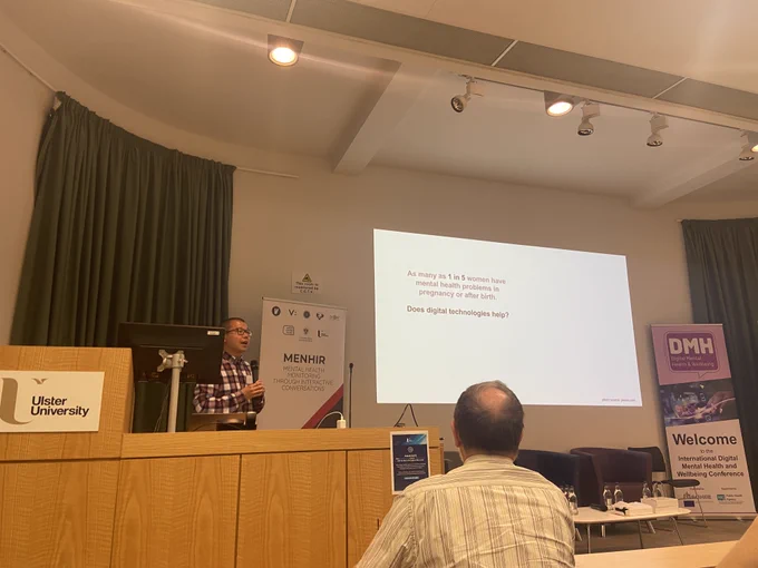 A photo of Zhen Zhu delivering a presentation on 'Maternal Mental Health Monitoring in an Online Community: A Natural Language Processing Approach'.