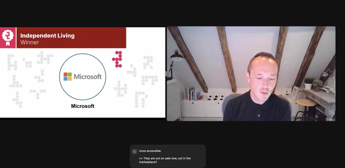 Screenshot of a slide reading "Independent Living Winner" and John Helmes on screen. 