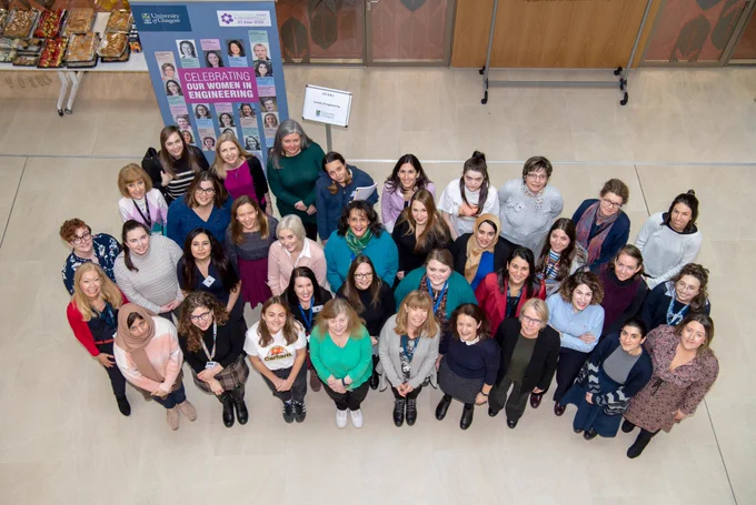 Female Engineerign staff and students from University of Glasgow looking upwards.