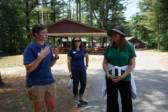 DOA Secretary Kathy Blumenfeld is shown the outdoor grounds of Easterseals Wisconsin Camp Respite by Anna Korb and Cally Ehle. 