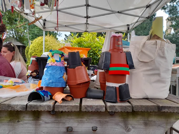Three homemade plantpot gnomes sit on a table outside 