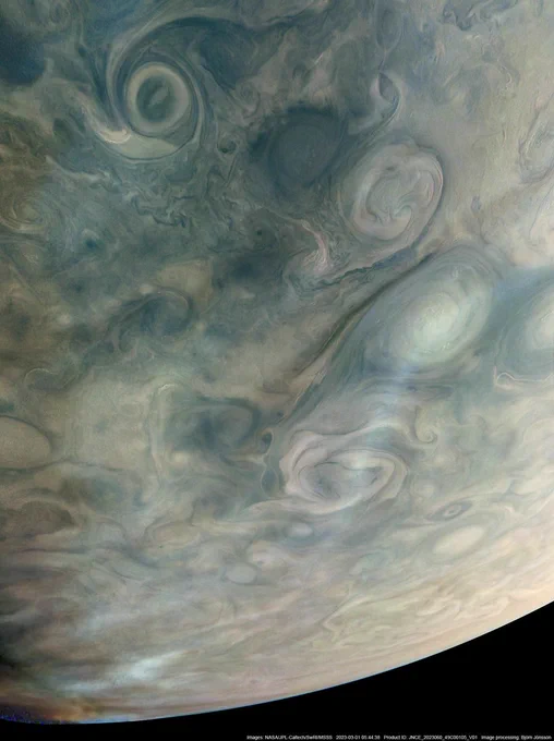 Swirling storms in hues of blue and green and the curving horizon of Jupiter with the darkness of space beyond. Above the spiraling clouds of the cyclones are wispy, light colored bands of haze.
Image data: NASA/JPL-Caltech/SwRI/MSSS
Image processing by Björn Jónsson © CC NC SA