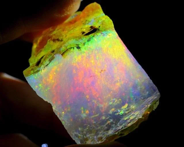Precious opal shows a variable interplay of internal colors, and though it is a mineraloid, it has an internal structure. At microscopic scales, precious opal is composed of silica spheres some 150–300 nm (5.9×10−6–1.18×10−5 in) in diameter in a hexagonal or cubic close-packed lattice... these ordered silica spheres produce the internal colors by causing the interference and diffraction of light passing through the microstructure of the opal. 

The regularity of the sizes and the packing of these spheres is a prime determinant of the quality of precious opal. Where the distance between the regularly packed planes of spheres is around half the wavelength of a component of visible light, the light of that wavelength may be subject to diffraction from the grating created by the stacked planes. The colors that are observed are determined by the spacing between the planes and the orientation of planes with respect to the incident light.

 from wikipedia 