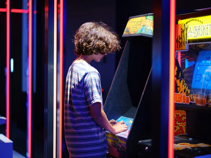 A child plays a retro arcade videogame.