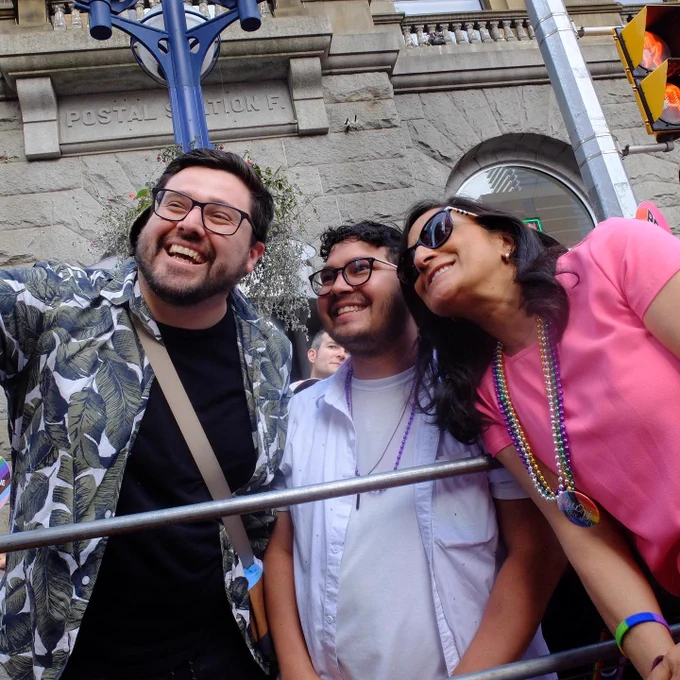 Minister Anand taking a picture with two men during Toronto Pride Parade.