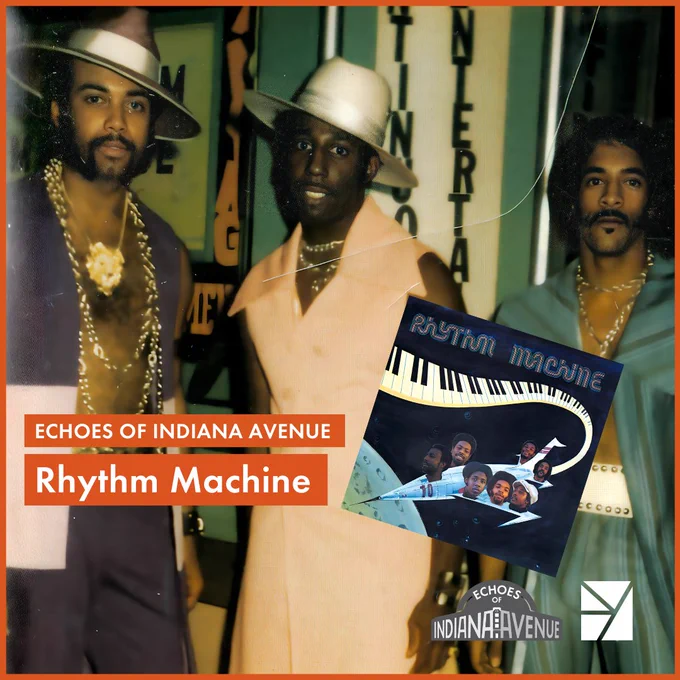 Three men in fancy suits and long golden chains. Two of the men are wearing fancy hats and the other has long black hair. Text in the bottom left of the corner read: Echoes of Indiana Avenue Rhythm Machine. 