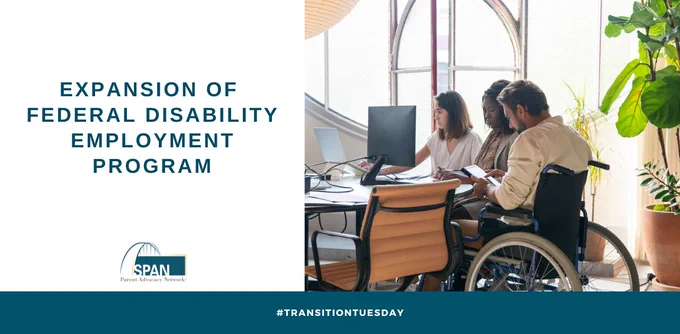 Young man in wheelchair sits at table with colleagues in workplace setting