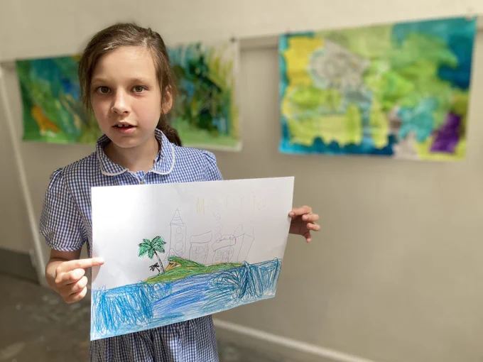 One of the older pupils holding her drawing of the island.