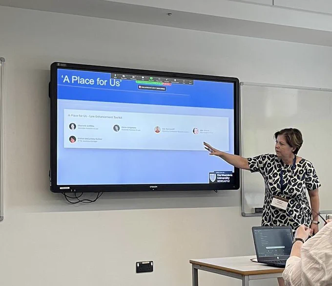 Photo of a conference presentation in the legal education stream of a law conference for the Society of Legal Scholars. Lecturer is standing in front of a slide which has the title of the project on which is called ‘A Place for Us’ talking about disability in law school