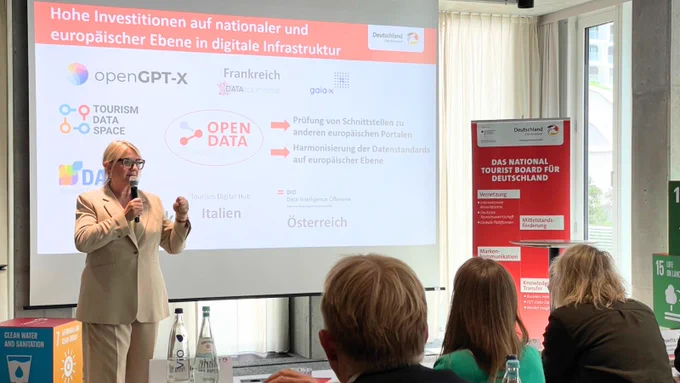 DZT Vorstandsvorsitzende Petra Hedorfer steht vor einer Leinwand mit einer Präsentation zum Launch des DZT Knowledge Graphen.