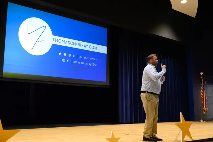 man standing on a stage giving a speech