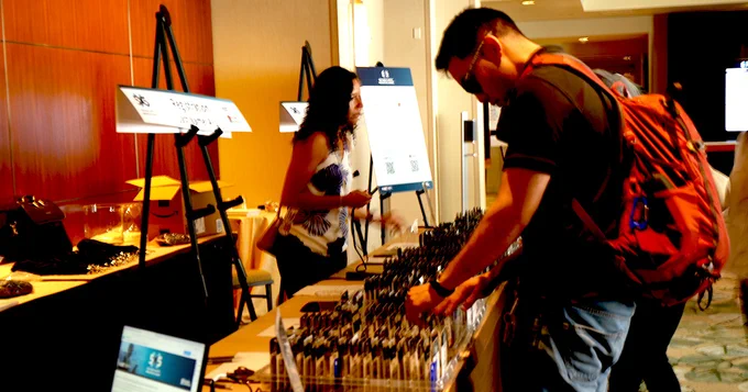a person looking through badges in the registration stand