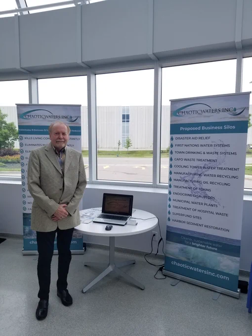 Aaron Morrison standing in front of Corporate Display at Enbridge. 