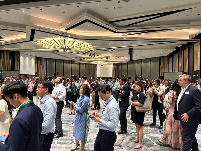 Photo of a room full of people in business corporate clothing.