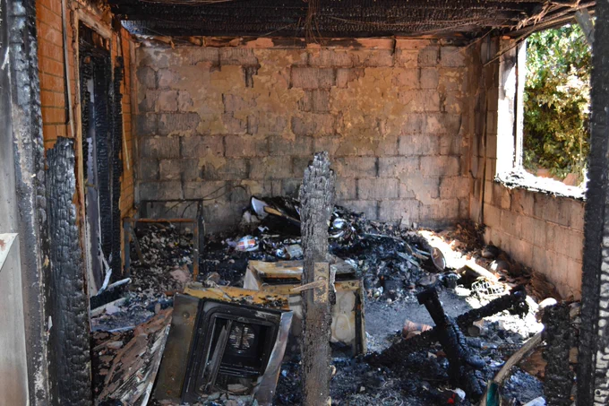 The kitchen which is unrecognisable and heavily fire damaged.