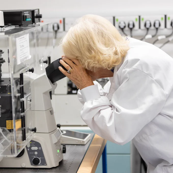 The Queen looking down a microscope in the advanced light microscopy lab