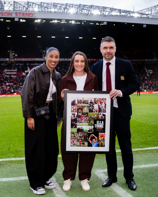 Gabby George and Matt Johnson alongside Ella Toone, who holds a special print to honour her recently being awarded an MBE.