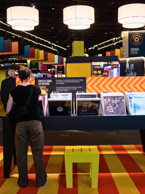 Visiteur observant les expositions au Musée, présentant des disques avec une ambiance colorée.