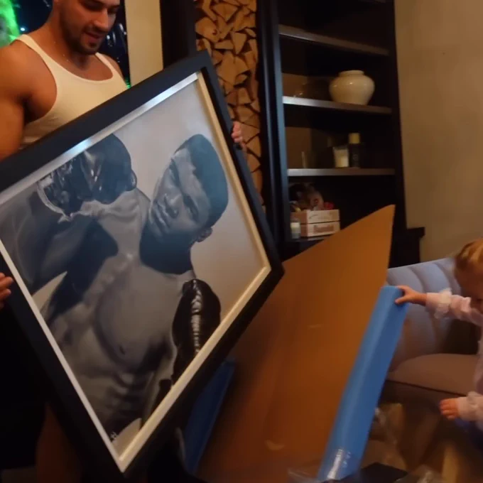 Tommy Fury opening his Christmas gift from Molly-Mae Hague, an original painting of Muhammad Ali by artist Pete Humphreys.