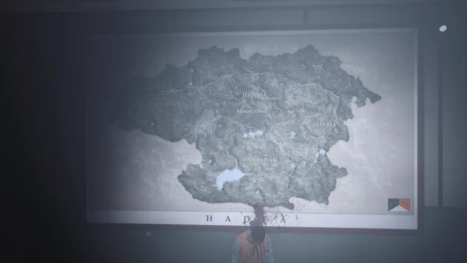 Karte von Hadea mit Blutspritzern
​Eine Innenaufnahme, die eine große, beleuchtete Landkarte an einer Wand zeigt. Die Karte trägt die Überschrift "HADEA" und zeigt Regionen wie "AARGAULA", "JEHANIA" (mit Mount Obek), "ASTERIA" und "UMBRAHAN". Unten rechts ist eine Flagge mit drei Sternen abgebildet. Vor der Karte steht oder kniet eine Person (möglicherweise ein Leichnam), deren Kopf nach unten hängt. Ein massiver Blutfleck spritzt genau von der Position des Kopfes nach oben auf die Karte und verdeckt den unteren Teil der Region Umbrahan.