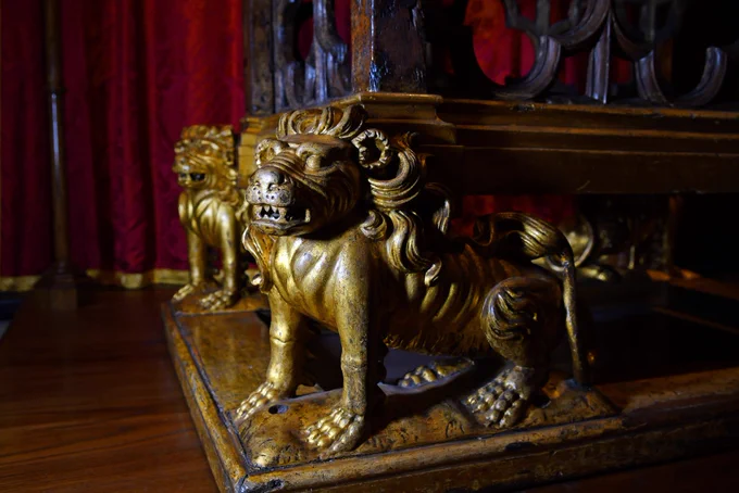 A close-up picture of a pair of gold gilt lions at the foot of the Coronation Chair