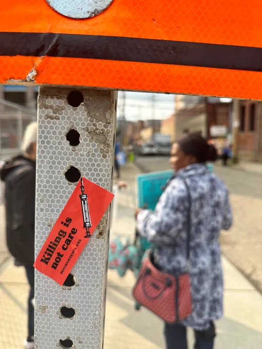 an orange sticker on a pole says "killing is not care"