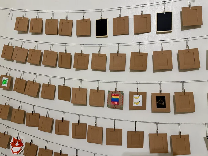 Mini art in cardstock frames hung up on strings.