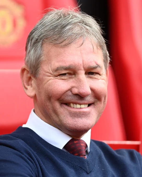 Bryan Robson smiles in the Old Trafford dugout.
