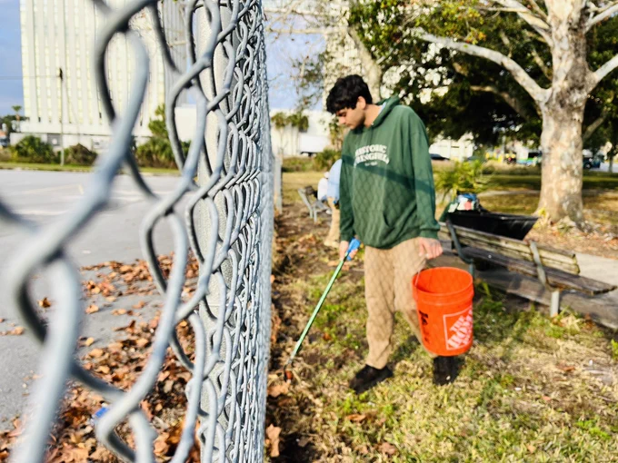 A person picking up litter with a grabber