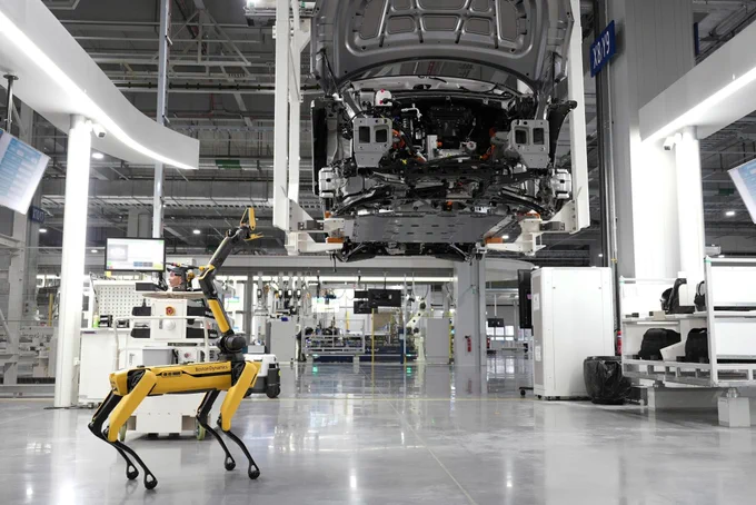 Automated automotive assembly line with robotic arms assembling vehicle components in a modern factory