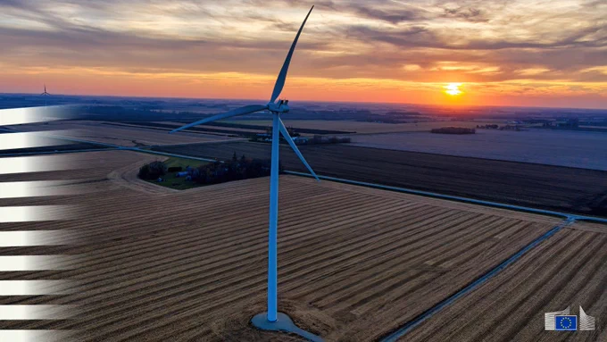 Agricultural landscape and wind turbines at sunset. 