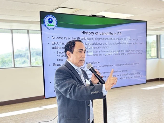 Eduardo R. González, Environmental Engineer, CEPD, EPA Region 2 speaking into a microphone has a screen behind him that says "History of Landfills in Puerto Rico" 